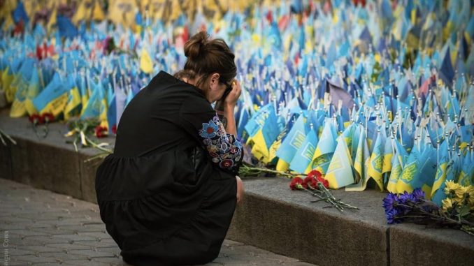 Una mujer ucraniana llora ante un monumento a los caídos en el que cada bandera simboliza un fallecido. Autor - Kostiantyn Sova.
