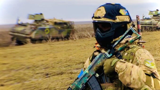 Miembro de la 65ª Brigada Mecanizada ucraniana posa delante de sendos blindados YPR-765. Nótese el detalle de la katana en la espalda del infante. Fuente - @MilitaryLandNet