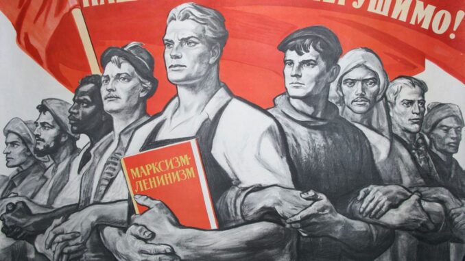 Conocido cartel propagandístico soviético en el que un proletario sostiene un libro sobre "Marxismo-Leninismo" bajo una bandera en la que figura el lema "Nuestra unión es indestructible". Fuente - Artpal